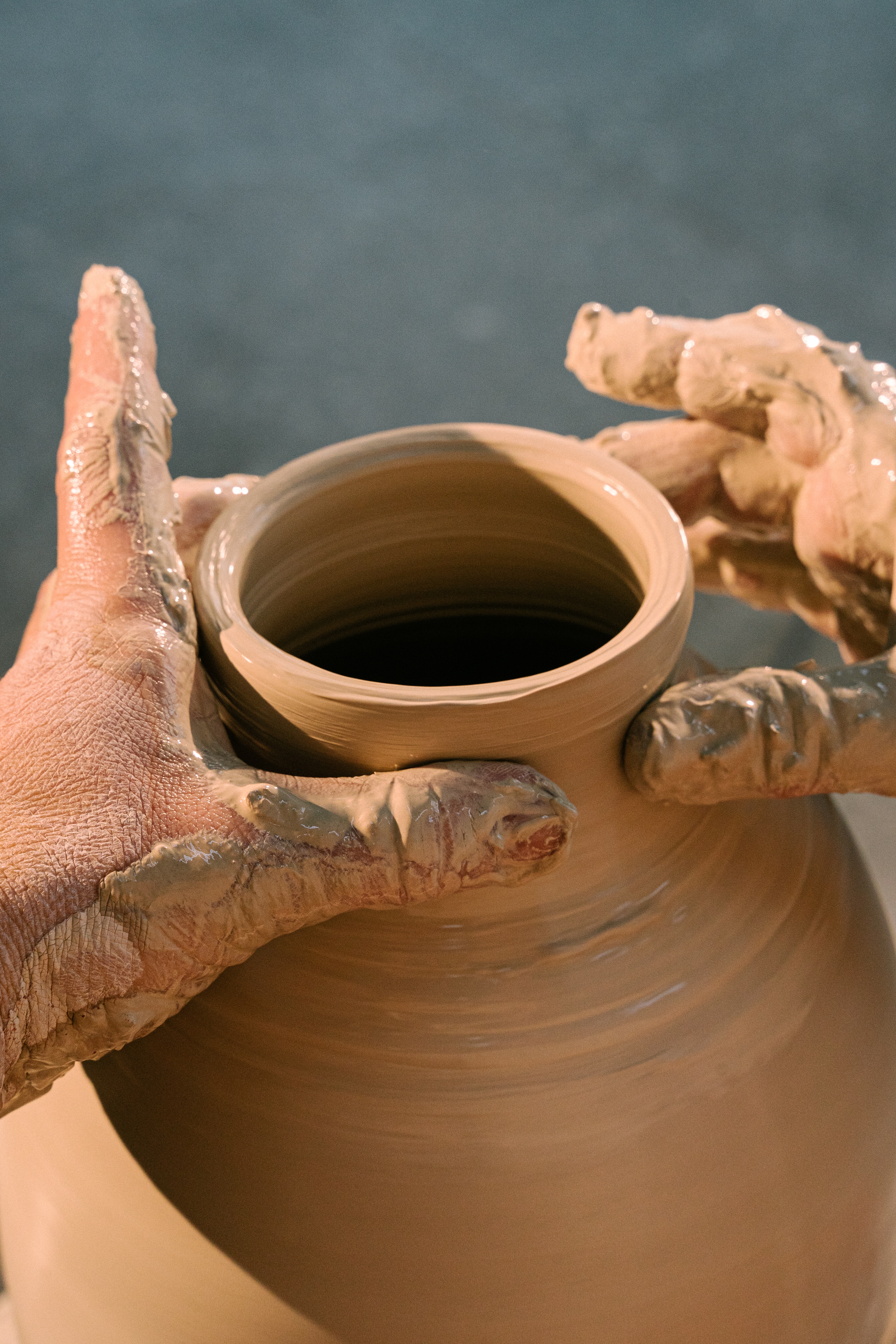 hands doing pottery with a clay pot